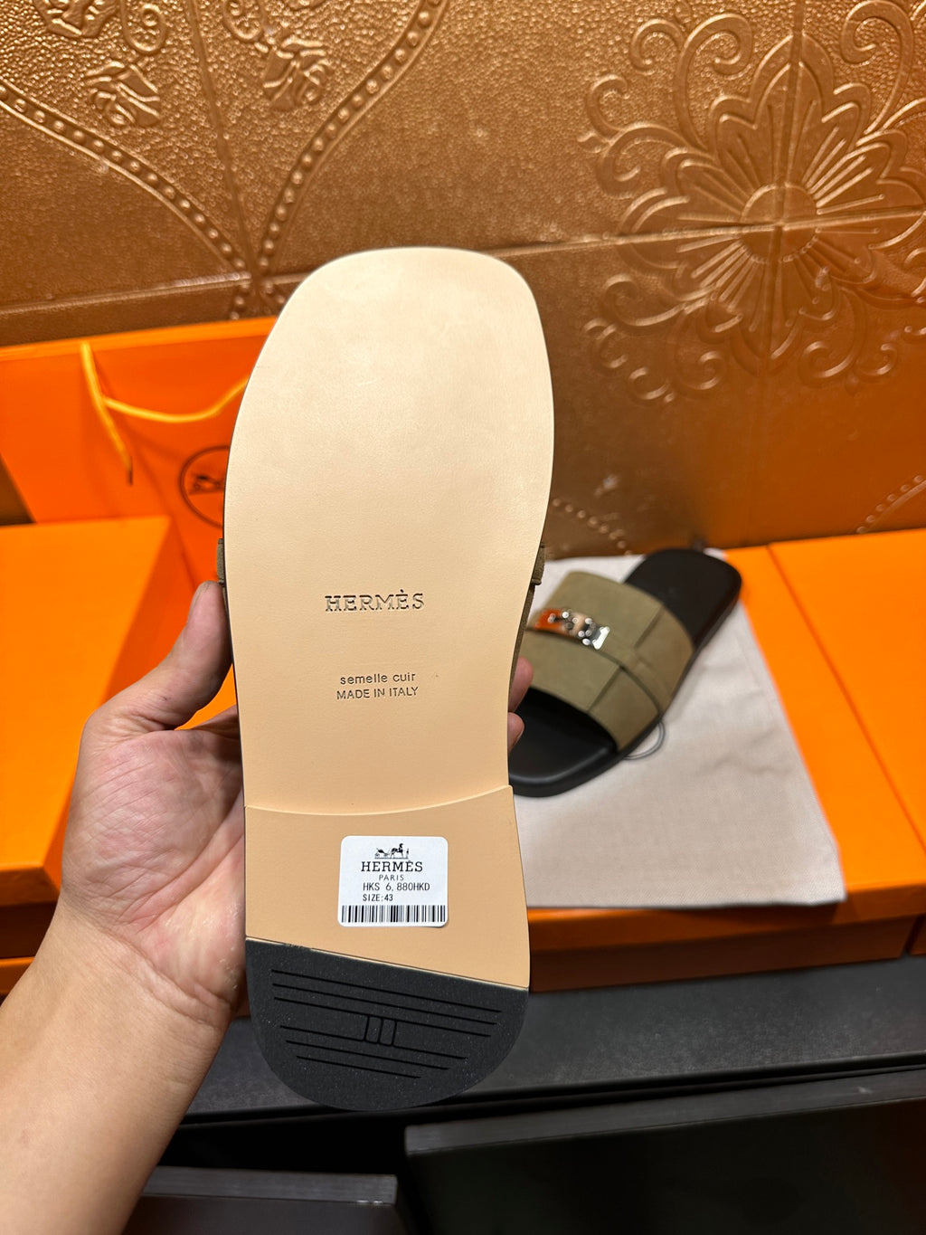 Hermes sandal sole bottom with text and tread, paired with olive green slide sandal