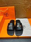 Hermes luxury sandals with black slide straps and silver-tone rectangular buckle detail