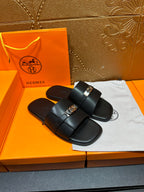 Hermes luxury black sandals with wide strap and silver-tone buckle, front view