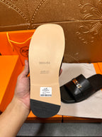 Hermes luxury sandal sole with black tread and label, showing underside