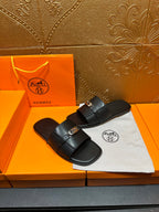 Hermes luxury black slide sandals with single wide strap and silver-tone buckle