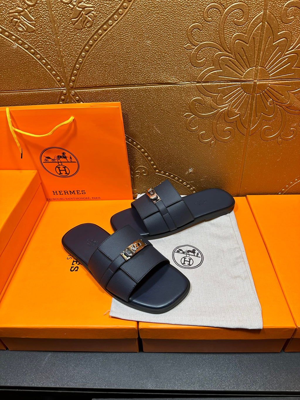 Navy leather slide sandals with double strap and gold-tone buckle, side view
