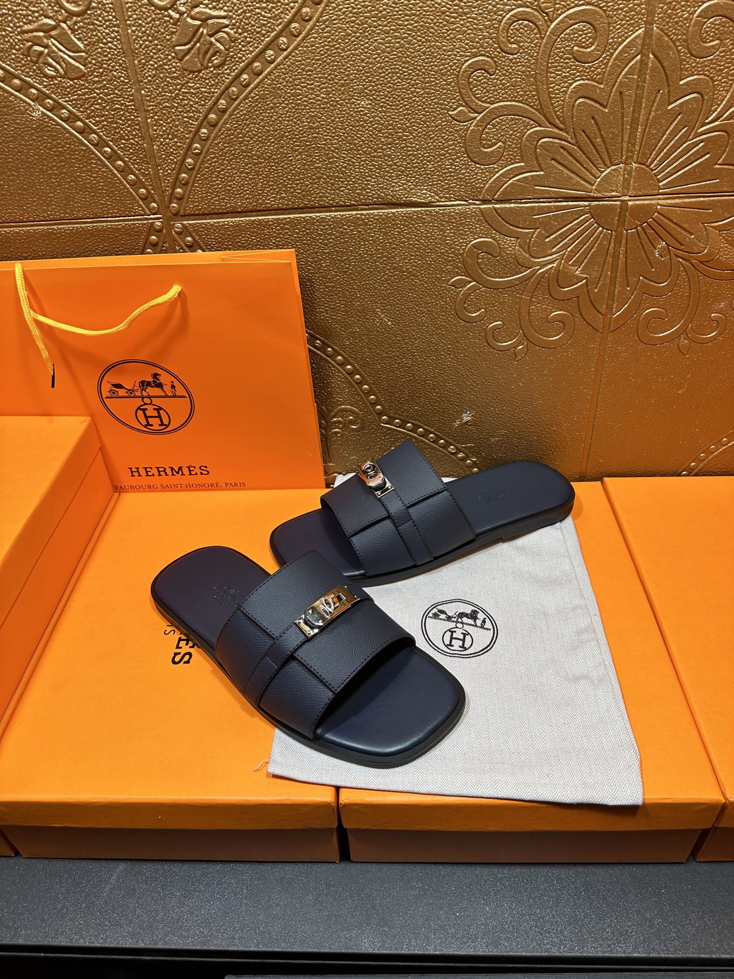Navy leather slide sandals with double strap and gold-tone buckle, side view