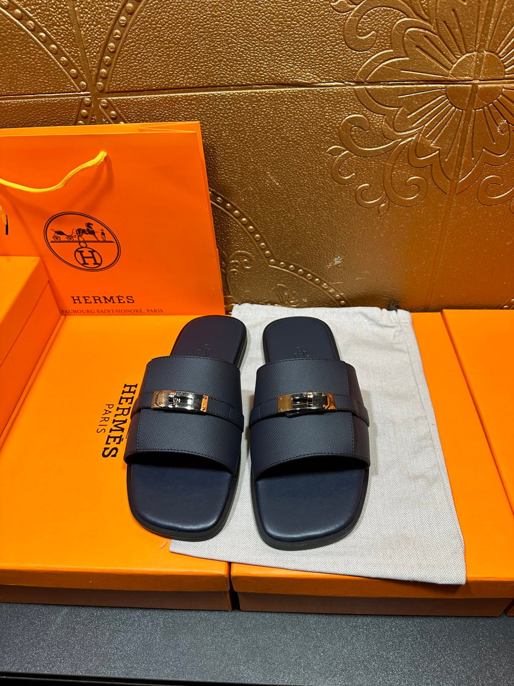 Navy leather slide sandals with adjustable strap and gold-tone buckle
