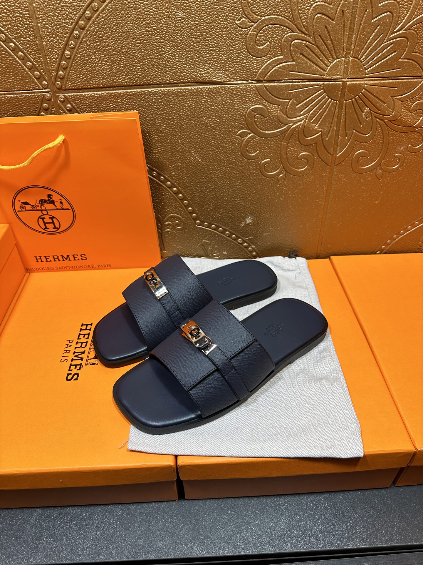 Navy leather slide sandals with double straps and gold-tone buckle