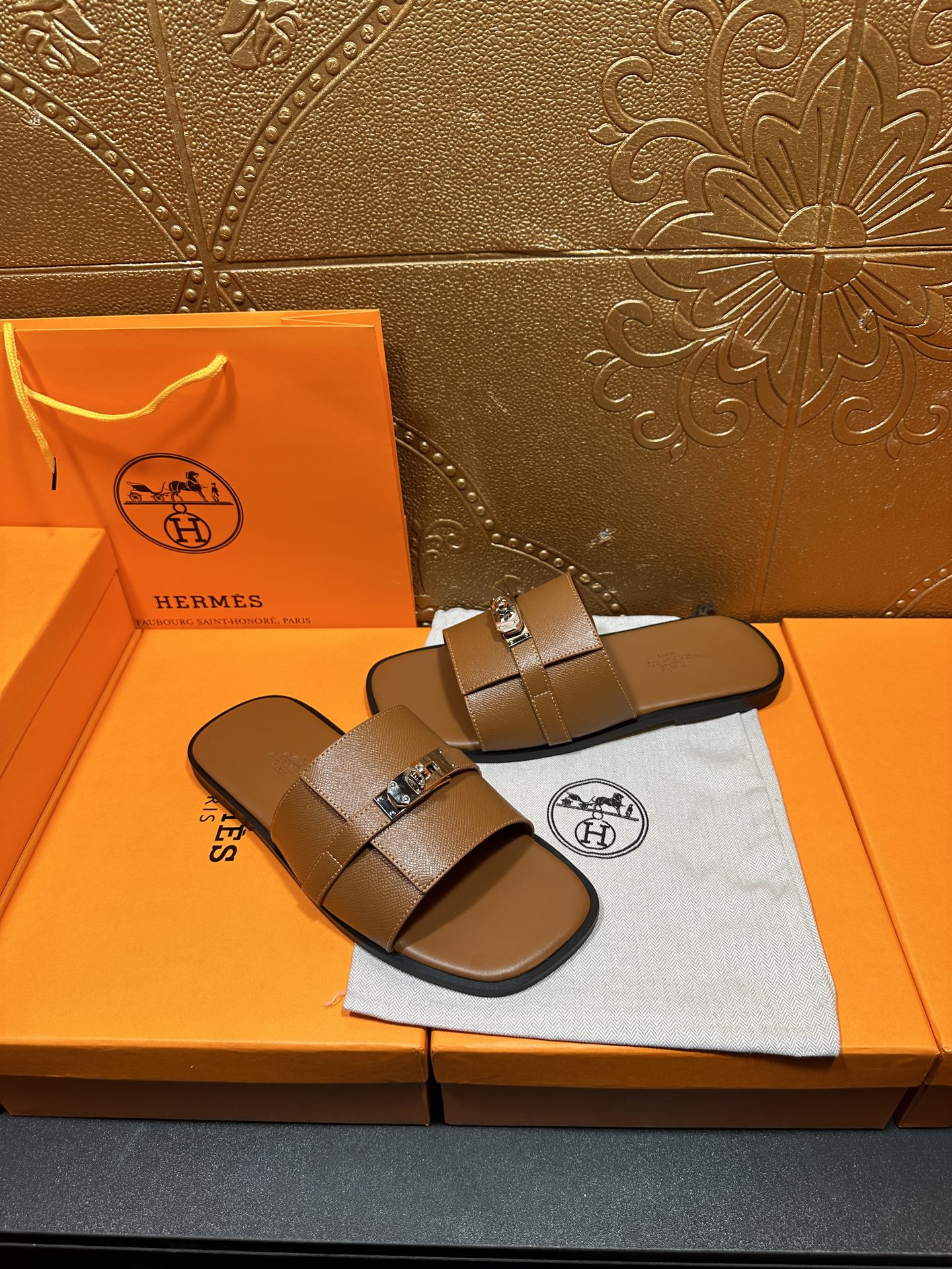 Brown leather slide sandals with two wide straps and square buckle, side angle