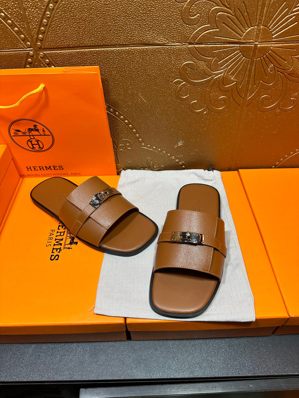 Brown leather slide sandals with two wide straps and square buckle hardware