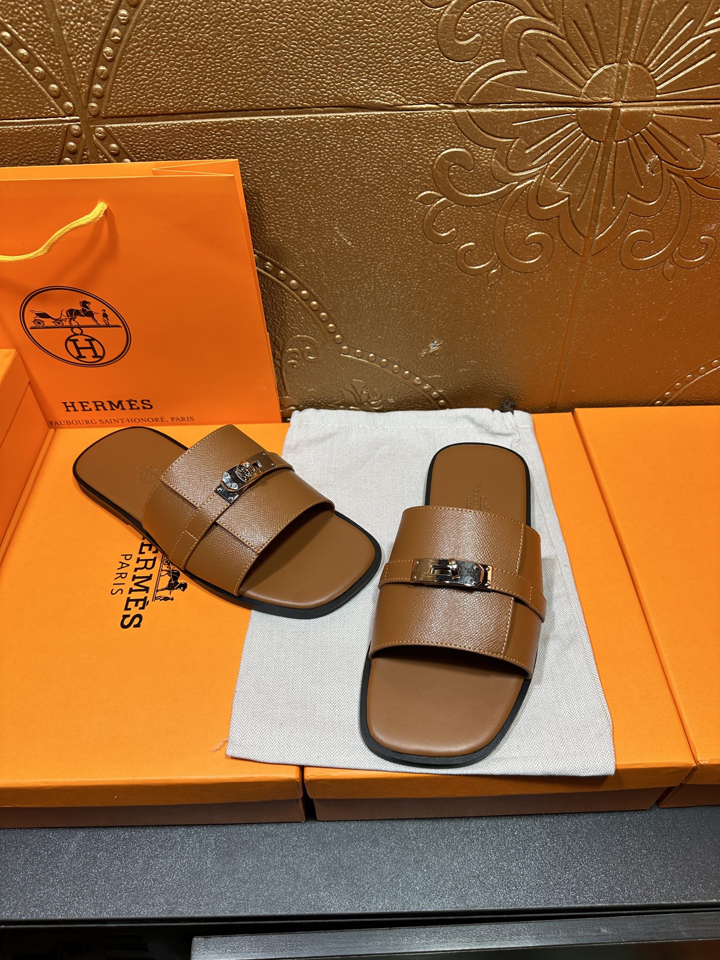 Brown leather slide sandals with two wide straps and square buckle hardware