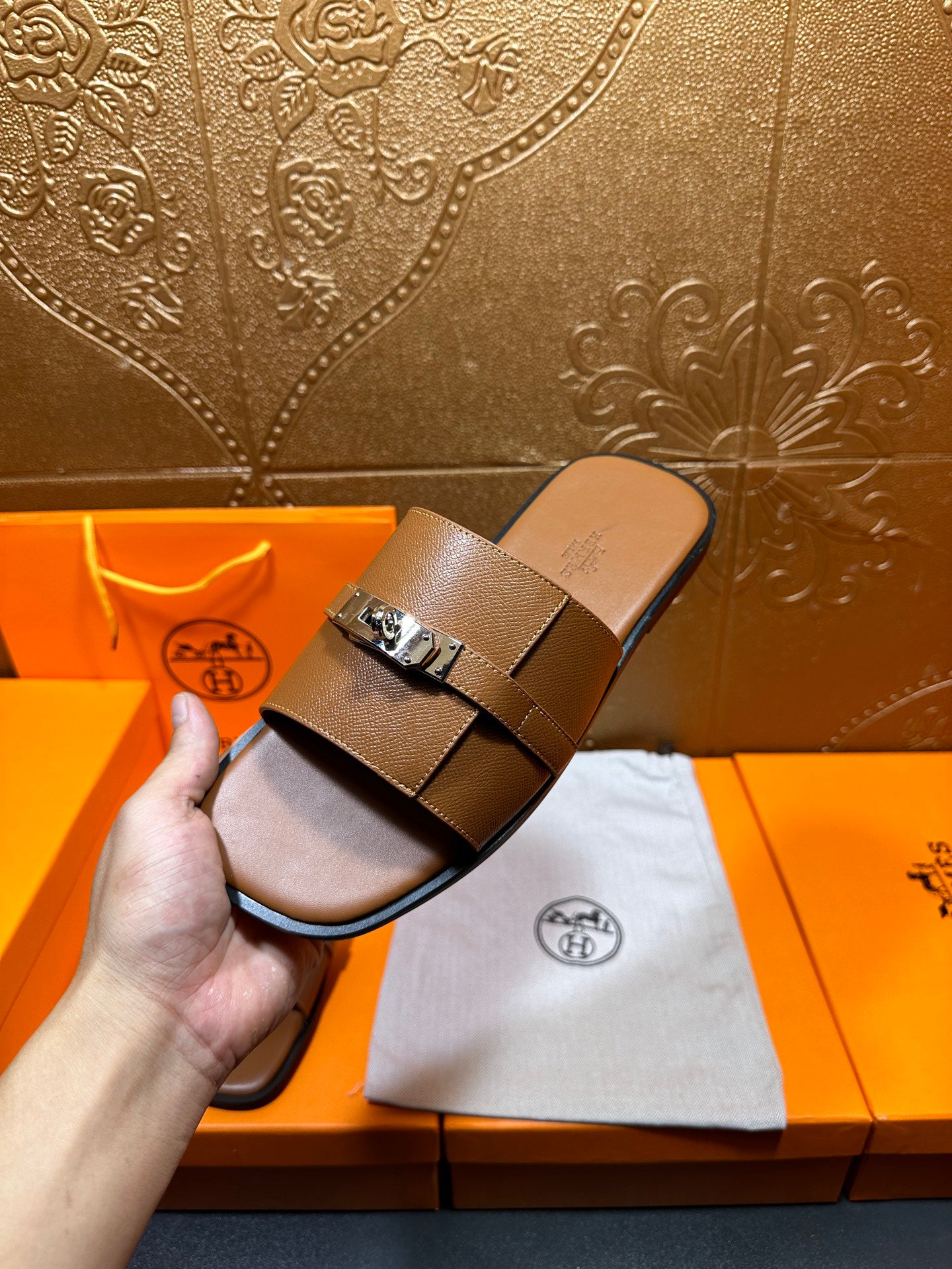 Brown leather slide sandal with square buckle on two wide straps, held