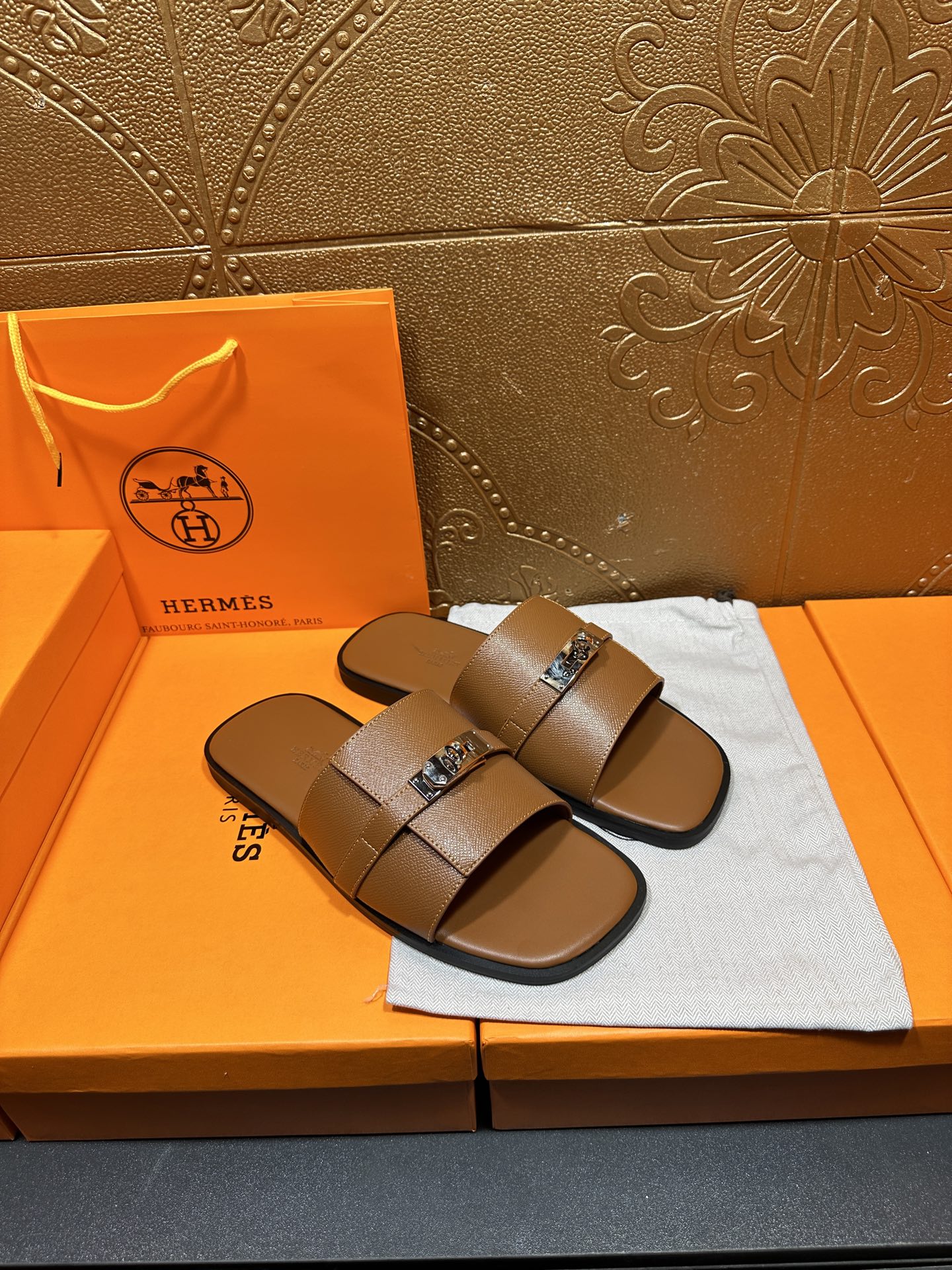 Brown leather slide sandals with double straps and square buckle, pair angled