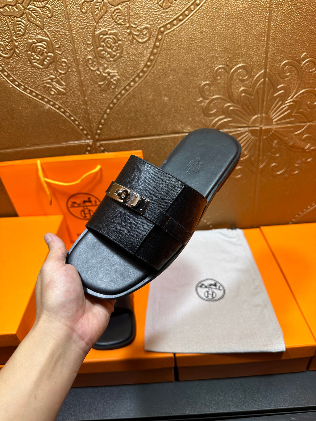 Hermes black leather slide sandal in hand, footbed with strap and buckle