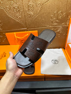 Brown leather slide sandal with gray footbed and embossed logo strap