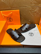 Brown leather slide sandals with embossed logo on wide cross strap