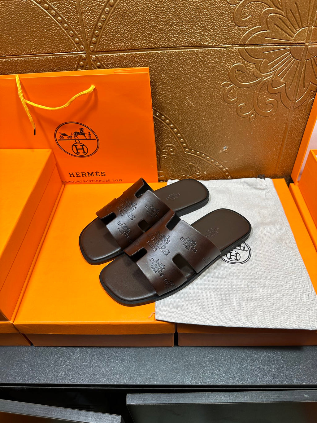 Brown leather slide sandals with embossed logo on the wide cross strap