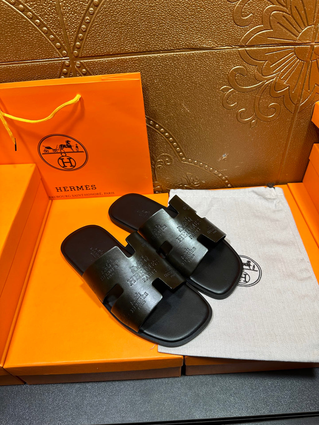 Hermes black slide sandals with wide embossed straps and open toe