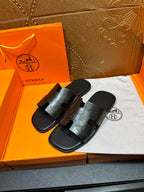 Hermes black slide sandals with embossed H-detail straps, open toe