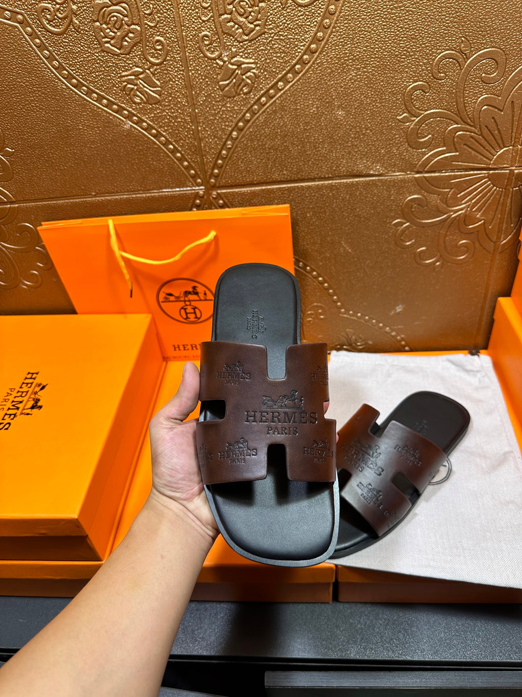 Hermes slide sandals shown from top; wide dark strap with embossed logo