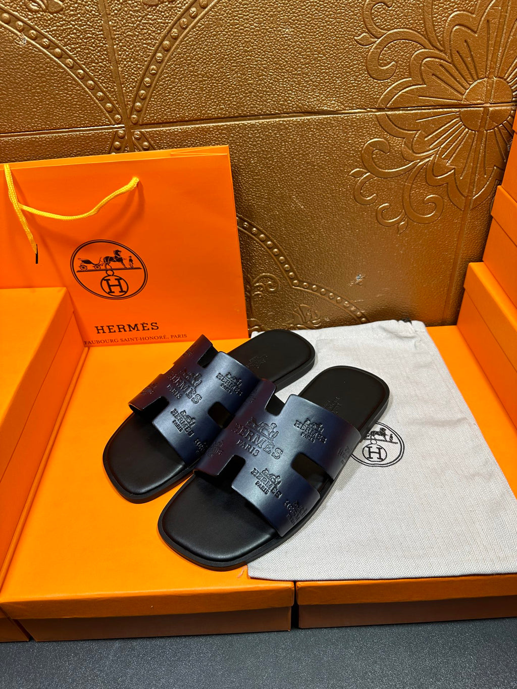 Hermes slide sandals, dark blue, showing two front straps with embossed logo