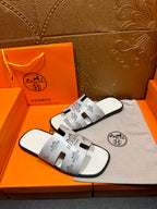 Hermes white slide sandals with black logo print cross strap