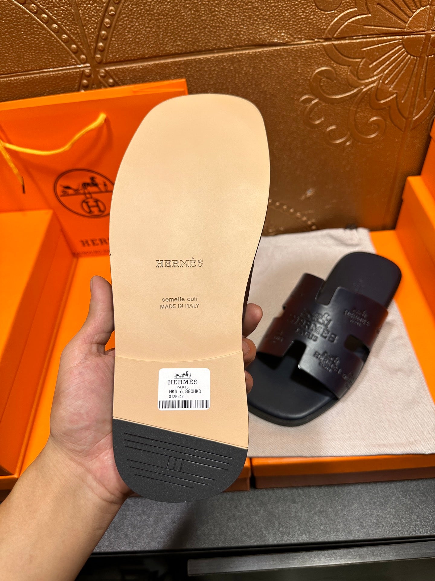 Hermes slide sandal sole, light interior label and dark rubber outsole shown.