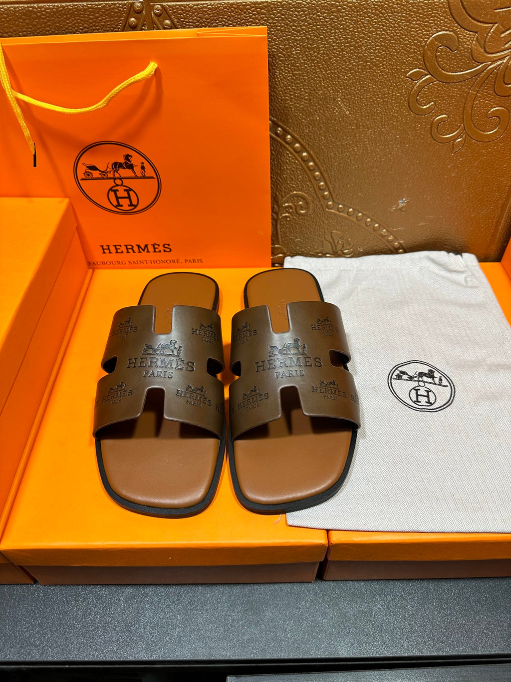 Dark gray leather slide sandals with wide logo strap and open toe