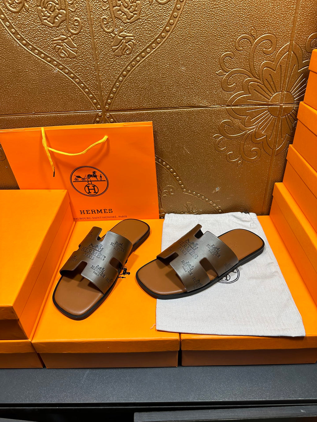 Dark gray slide sandals with embossed straps and open toe on flat sole