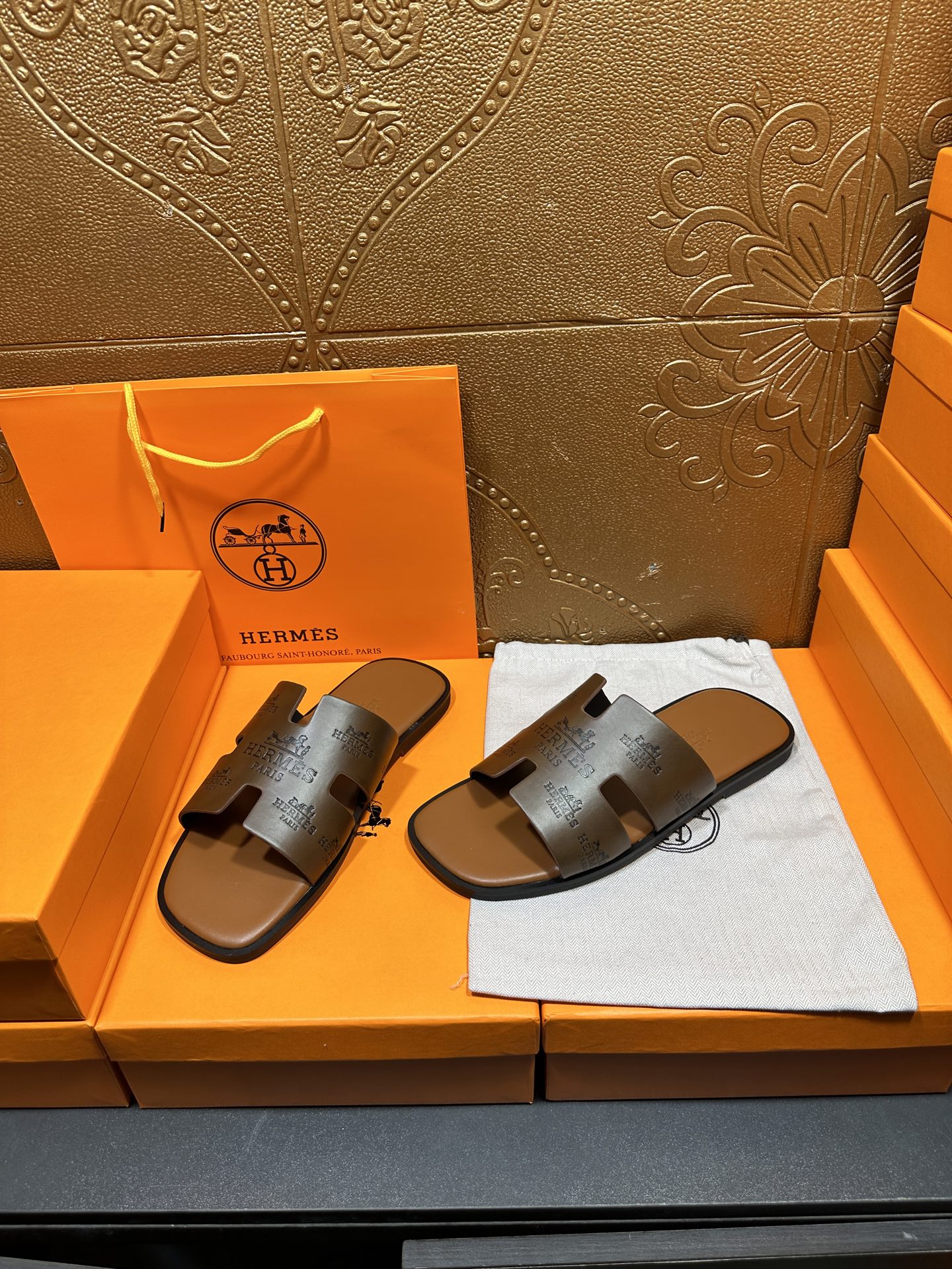 Dark gray slide sandals with embossed straps and open toe on flat sole