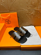 Hermes slide sandals, top view of two dark straps with embossed logo