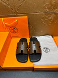 Hermes slide sandals with dark brown logo-print straps and black soles