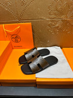 Hermes slide sandals with dark brown printed footbeds and black rubber soles