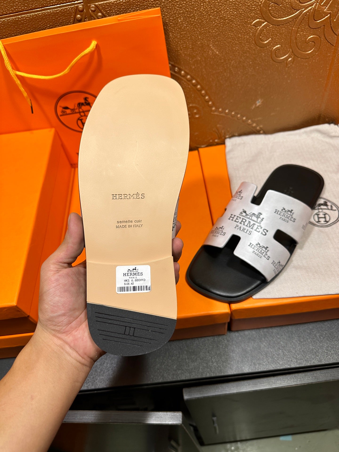 Hermes sandal outsole showing dark tread and white label on the sole