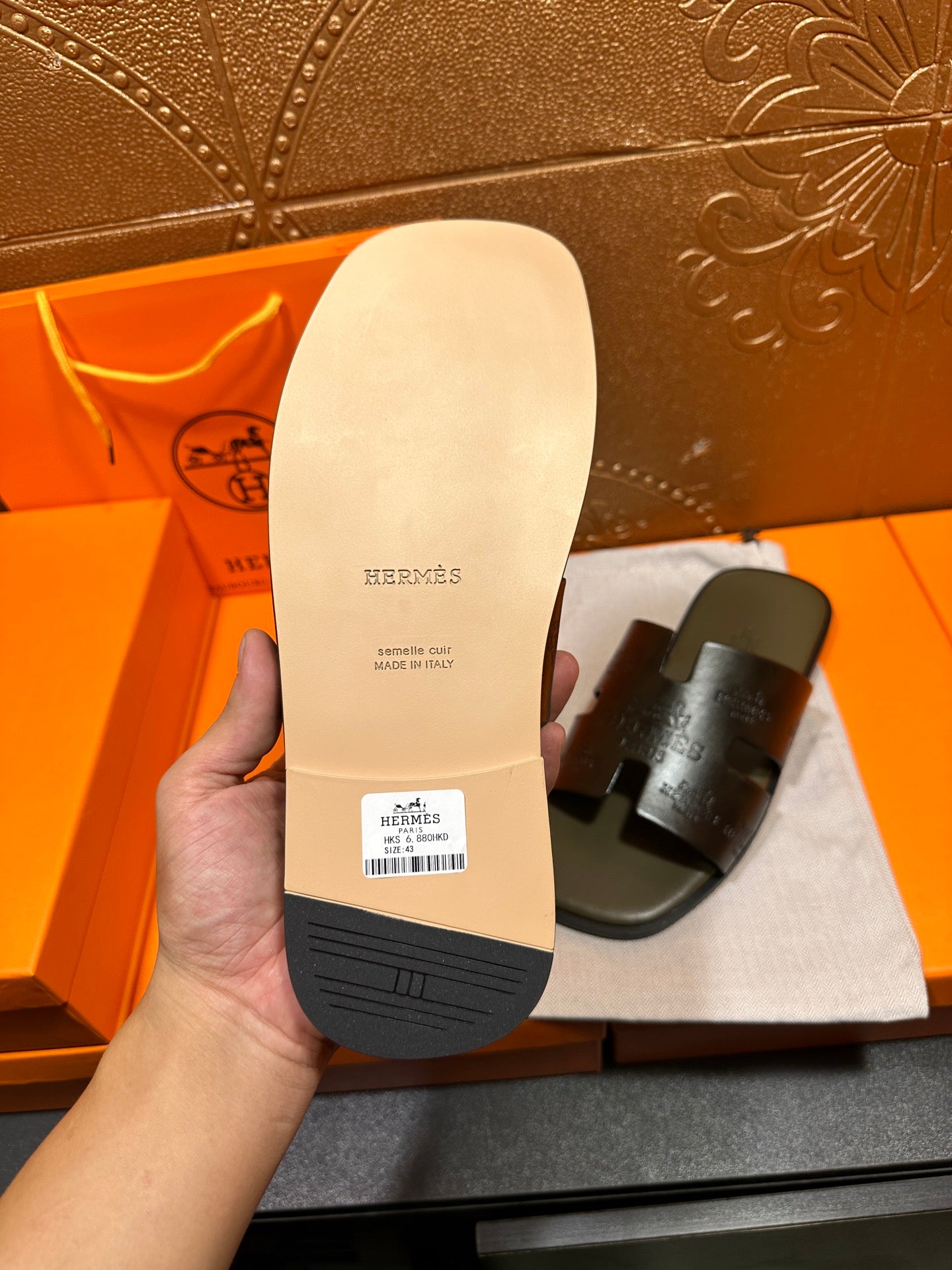 Sandal sole underside, light tan rubber with logo and grip tread