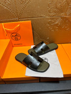 Black slide sandals with logo-embossed straps and open toe