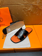 Hermes slide sandals with beige outsole and orange footbed, pair