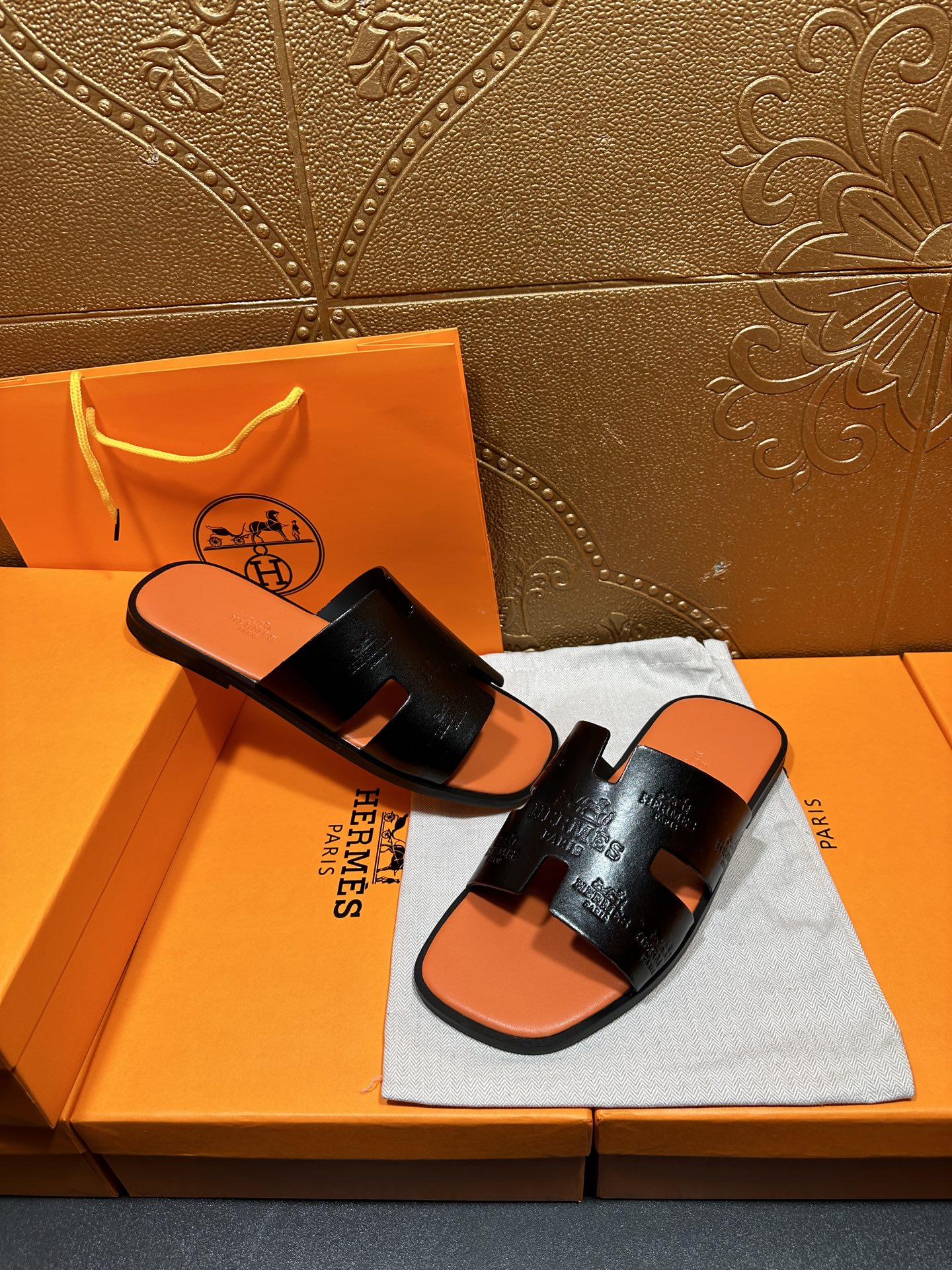 Hermes slide sandals, black embossed straps and orange footbed, pair
