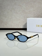 Black oval sunglasses with gold hinge logo and blue-tinted lenses