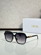 Dior sunglasses with black frame and dark lenses, gold hinge detail