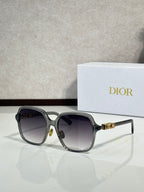 Dior sunglasses with translucent gray frame and dark tinted lenses, gold accents