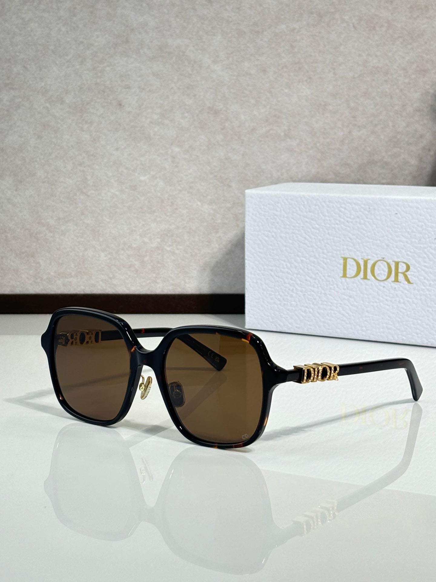 Dior sunglasses with black frame and brown-tinted lenses, gold accents