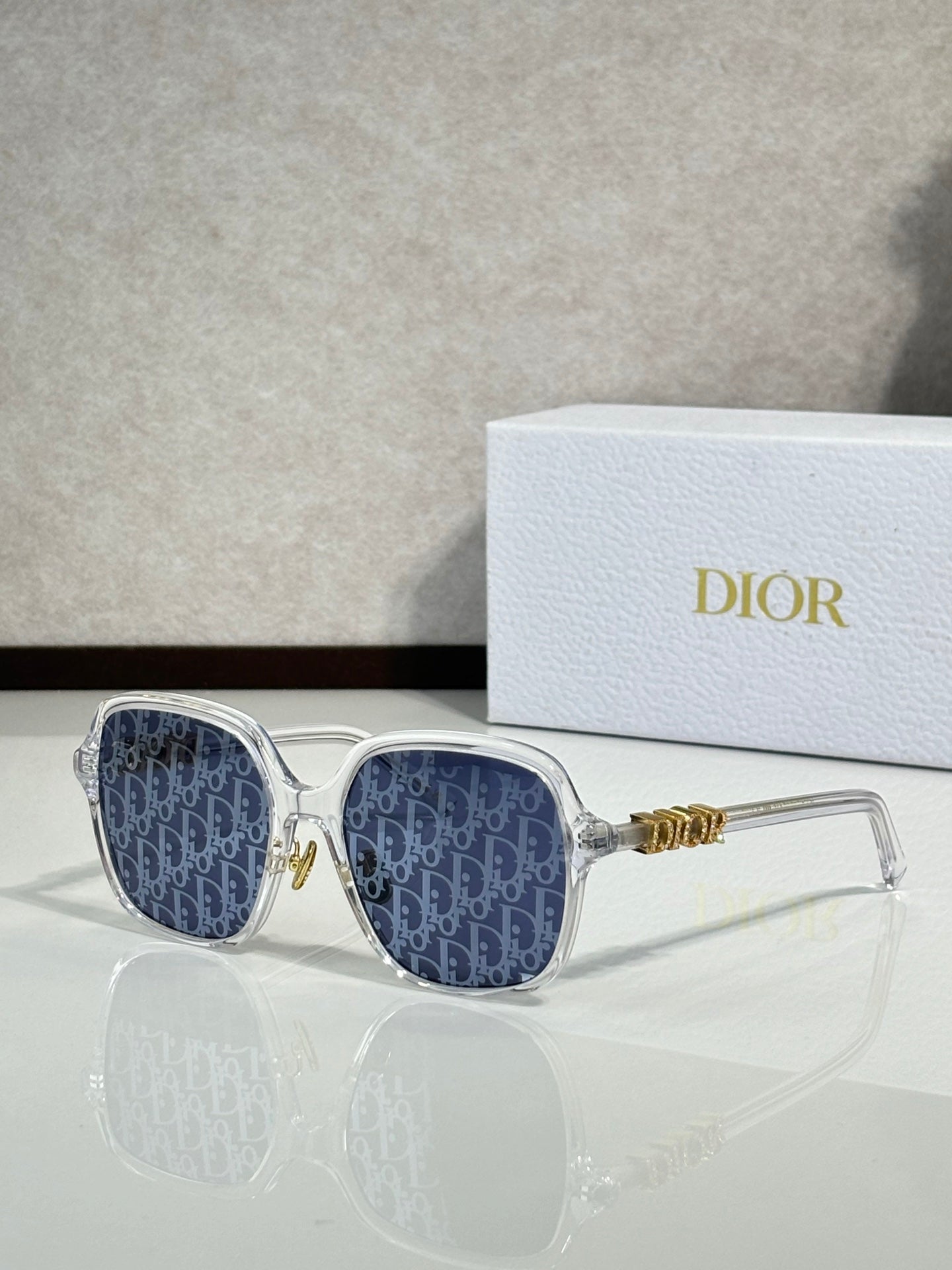 Dior sunglasses with clear frame and blue patterned lenses, gold accents