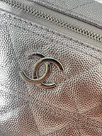 Chanel logo hardware on silver-tone quilted bag front with zipper track close-up