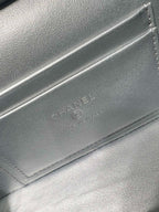 Chanel embossed mark on silver-tone bag flap with stitched edge detail