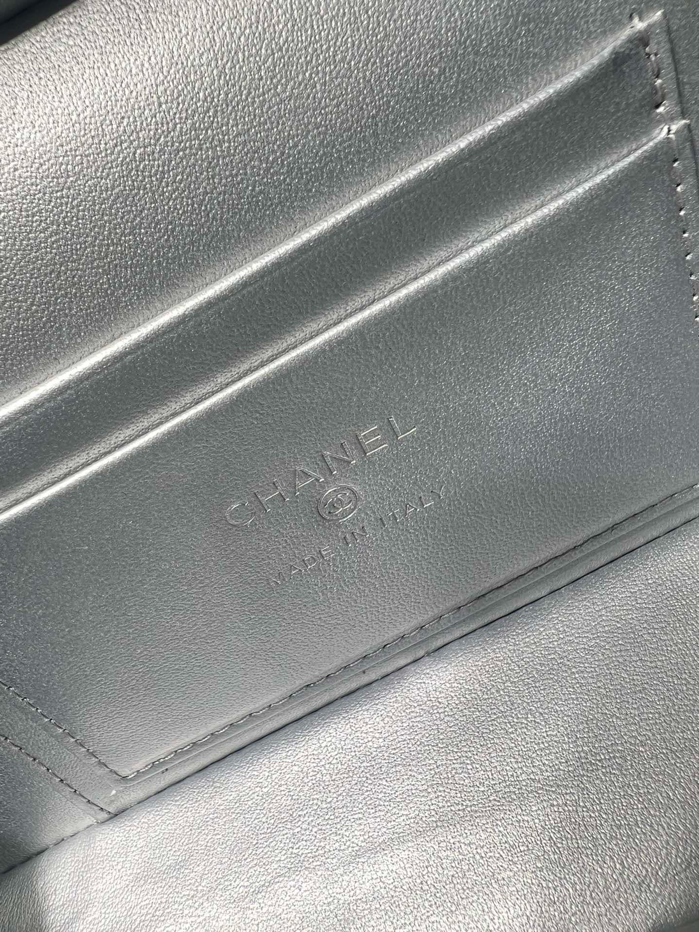 Chanel embossed mark on silver-tone bag flap with stitched edge detail