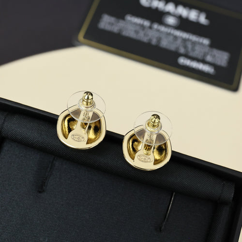 Gold-tone button stud earrings with Chanel-style logo on dark fabric pouch