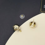 Gold-tone button stud earrings with Chanel-style logo on dark blue case insert