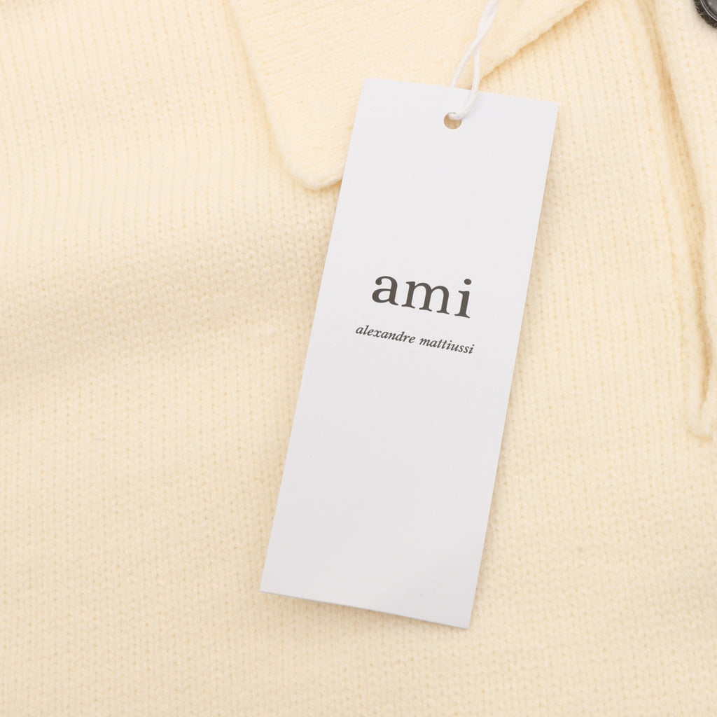Amiri knit sweater neckline tag with 'ami' logo, cream polo knit