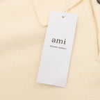 Amiri knit sweater neckline tag with 'ami' logo, cream polo knit
