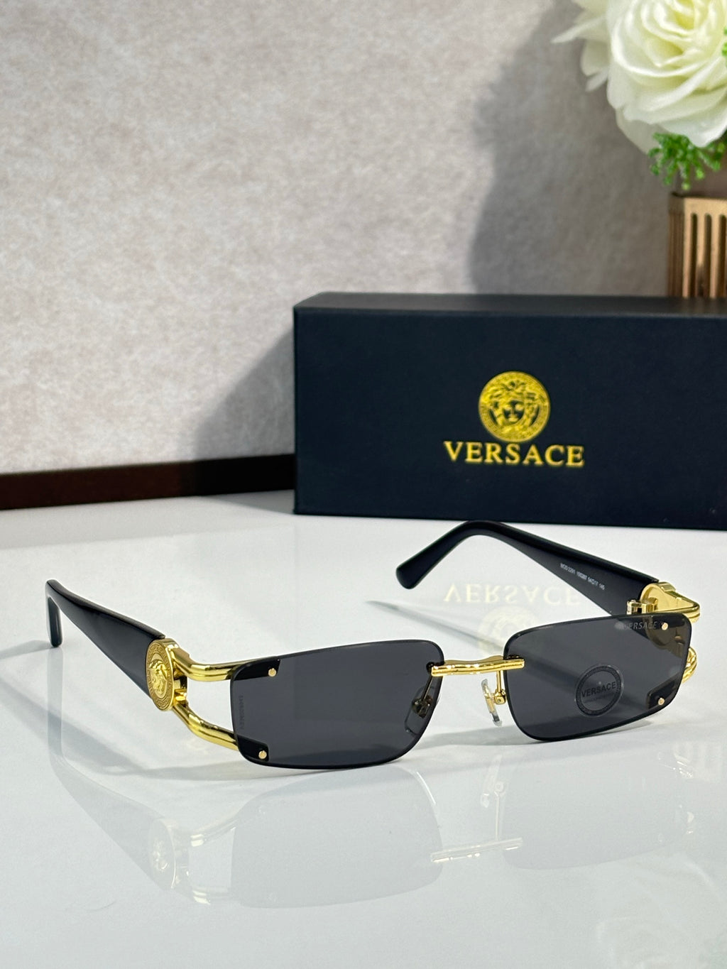 Gold-tone sunglasses with black tinted lenses and ornate temple detail