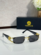 Gold-tone sunglasses with black tinted lenses and ornate temple detail