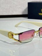 Light cream sunglasses with pink tinted lenses and gold-tone accents